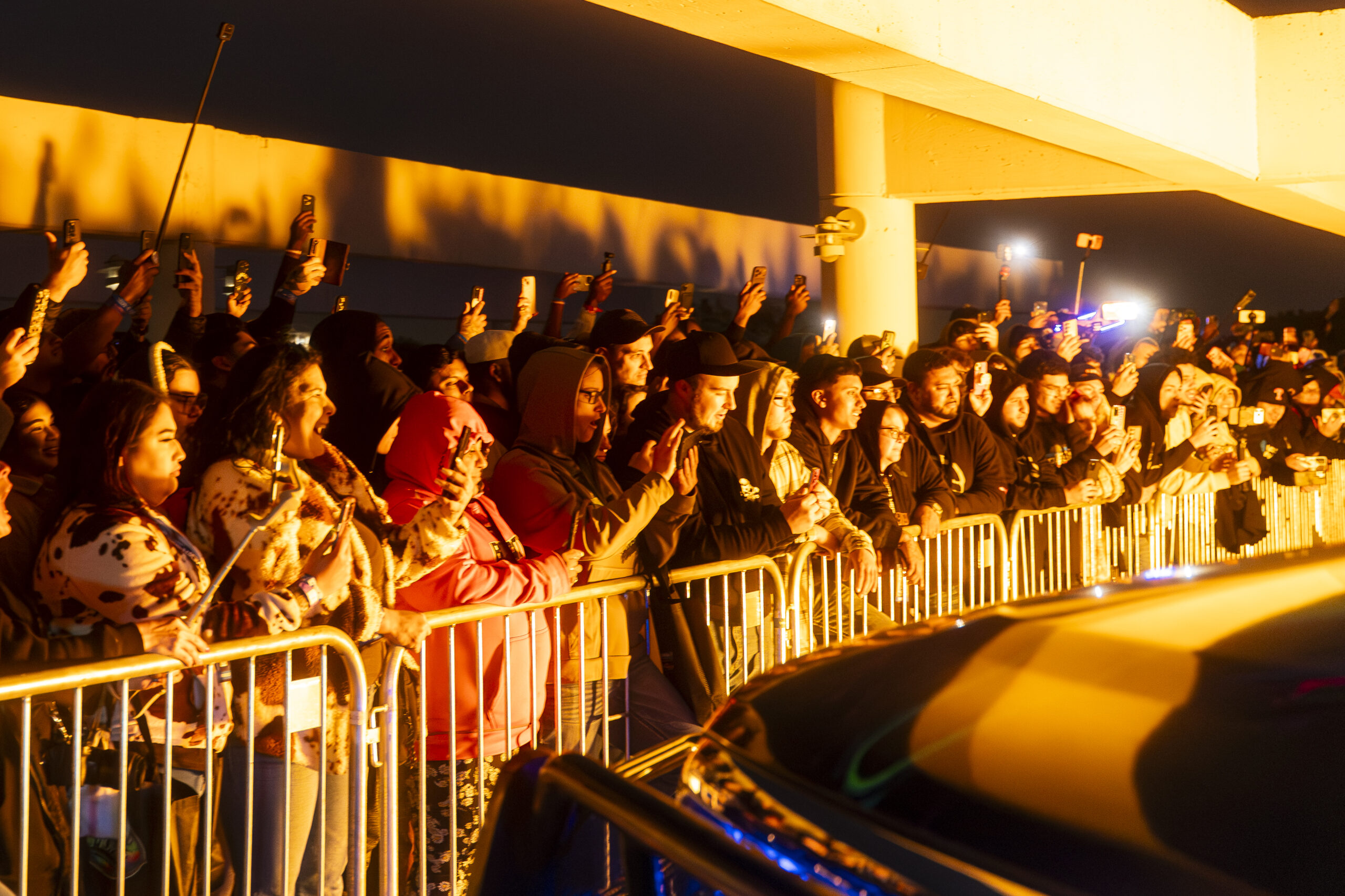Fans packed along the barrier as flames light up the night